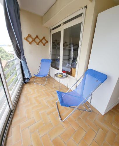 - deux chaises bleues et une table sur un balcon dans l'établissement T2 Le Saule Perché, 5p, beach 500m, terrace, park, à Fréjus
