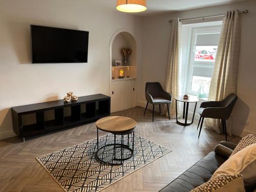 a living room with a couch and a table at 1 Links Place in Nairn