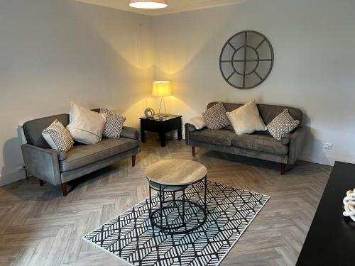 a living room with two couches and a table at 1 Links Place in Nairn