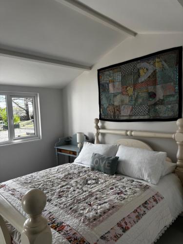 戈尔韦Rose Cottage的卧室里有一张床，墙上挂着一幅画