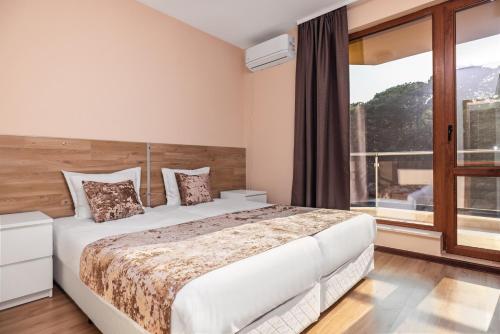 a bedroom with a bed and a large window at Nest Green Apartment Varna in Varna City