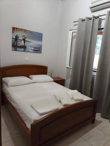 a bedroom with a large bed with white sheets at Paleros vacation in Paleros