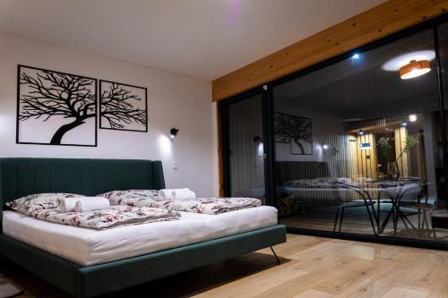 a bedroom with a bed and a glass door at JeLienka in Lietavská Závadka