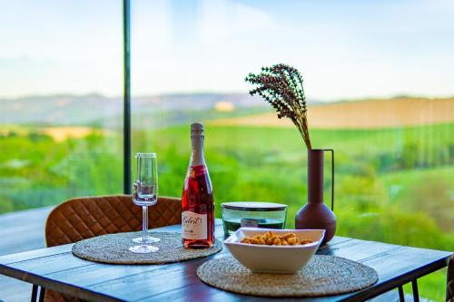 a table with a bottle of wine and a bowl of fruit at JeLienka in Lietavská Závadka