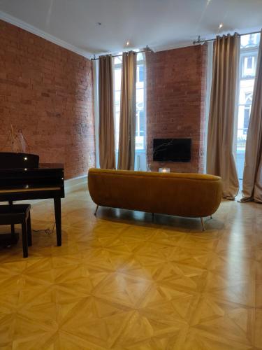 a living room with a couch and a piano at Versailles in Nottingham