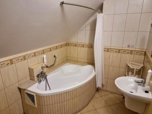 a bathroom with a bath tub and a sink at Hotel Hesperus in Międzyrzec Podlaski