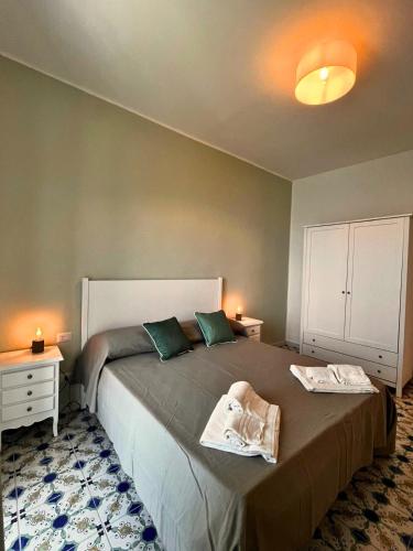a bedroom with a large bed with green pillows at Punta Fortino Resort in Agropoli