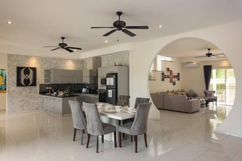 a kitchen and dining room with a table and chairs at Grand 5BR Pool Villa Sea la Vie in Rawai Beach