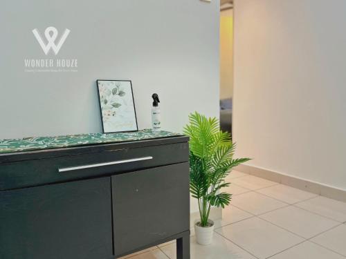 a black counter in a room with plants at 5pax Serene 3BR at Simfoni Heights with Batu Caves View in Batu Caves