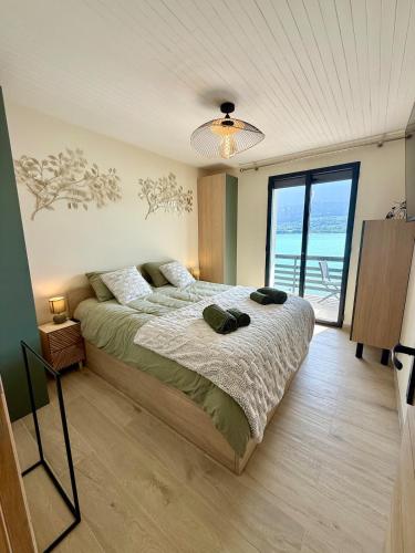 une chambre avec un lit avec vue sur l'océan dans l'établissement La Maison du Lac sleeps 10 and has air conditioning, à Talloires