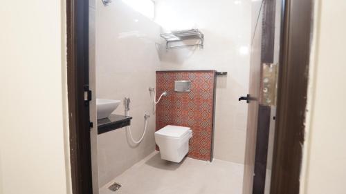 a bathroom with a toilet and a sink at Anantha Shaiya in Tiruchchirāppalli