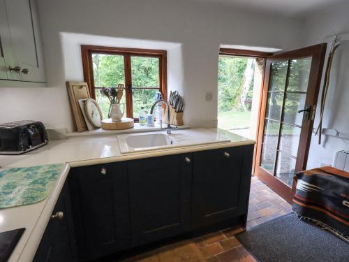 a kitchen with a sink and a window at Chapel Cottage in Cleator