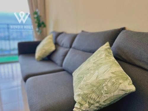 a blue couch with a yellow pillow on it at 5pax Serene 3BR at Simfoni Heights with Batu Caves View in Batu Caves