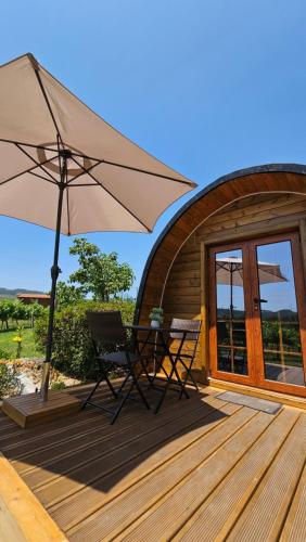 a patio with two chairs and an umbrella on a deck at Quinta Lama de Cima in Fafe