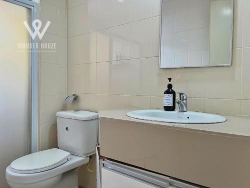 a white bathroom with a toilet and a sink at 5pax Serene 3BR at Simfoni Heights with Batu Caves View in Batu Caves