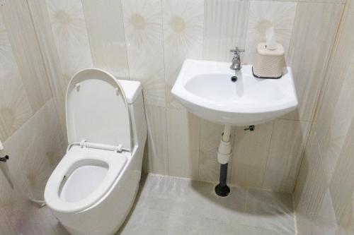 a bathroom with a toilet and a sink at Urbanview Botania Meeting Point Batam by RedDoorz in Nongsa