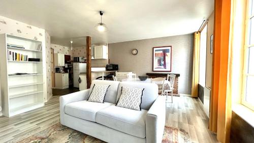 un salon avec un canapé blanc et une cuisine dans l'établissement Appartement 1 chambre avec terrasse, à Parthenay