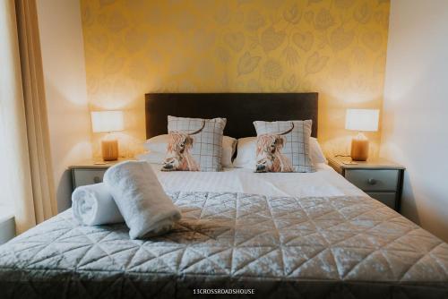 a bedroom with a bed with pillows and two lamps at Crossroads House in Carlisle