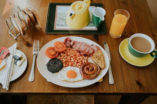 a plate of breakfast food on a wooden table at Crossroads House in Carlisle