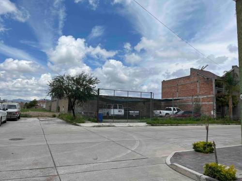 a parking lot with cars parked in front of a building at Bonito apartamento cerca de la zona comercial in Villa Hidalgo