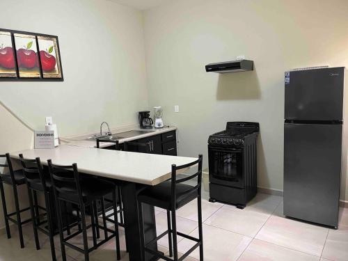 a kitchen with a refrigerator and a table and a stove at Bonito apartamento cerca de la zona comercial in Villa Hidalgo