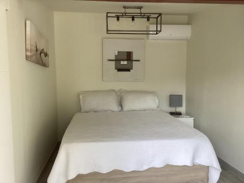 une chambre avec un lit avec un couvre-lit blanc dans l'établissement La bergerie Emma, à Éoures