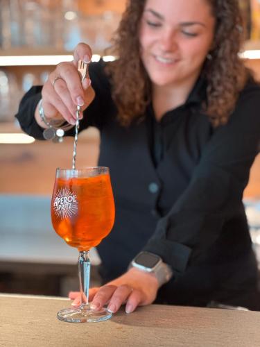 a woman sitting at a table with a wine glass at La Cipressina B&B in Cavaion Veronese