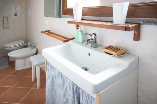 a bathroom with a white sink and a toilet at La casina incantata in Trevignano Romano