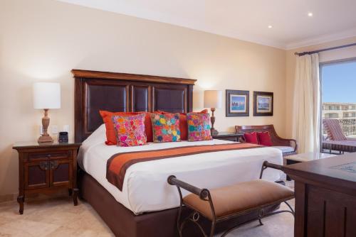 a bedroom with a large bed with colorful pillows at Unwind in Style Villa La Estancia Cabo in Cabo San Lucas