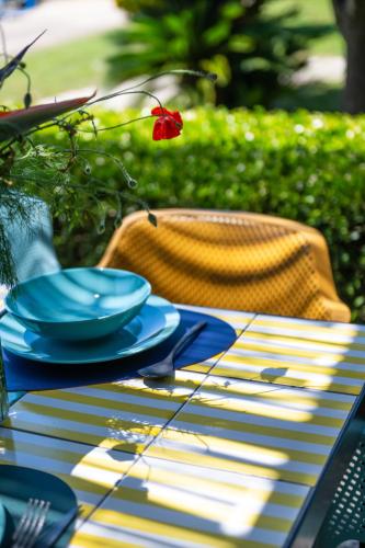 a table with blue plates and a red flower on it at 1912 Relais - Sorrento Coast in Piano di Sorrento