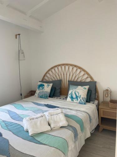 une chambre avec un grand lit avec des oreillers bleus et blancs dans l'établissement L'escapade, à Saint-Tropez
