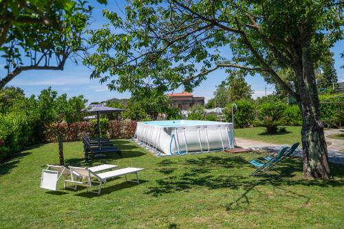 a swimming pool in a yard with chairs and a tree at 1912 Relais - Sorrento Coast in Piano di Sorrento