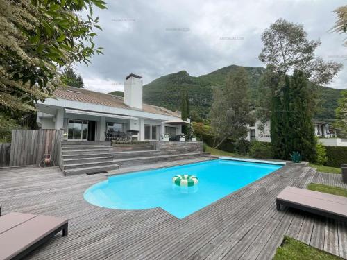 une arrière-cour avec une piscine bleue et une maison dans l'établissement Savoielac - Lac d'Annecy - Annecy-le-vieux : Villa Astrid, à Annecy