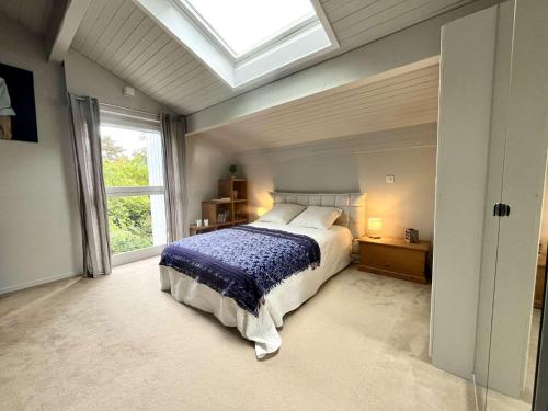une chambre avec un lit et une lucarne dans l'établissement Savoielac - Lac d'Annecy - Annecy-le-vieux : Villa Astrid, à Annecy