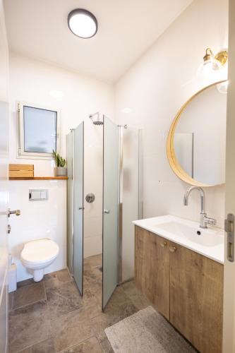 a bathroom with a sink and a toilet and a mirror at בגג העמק - וילה in HaZore‘im