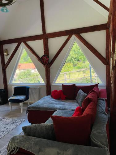 a room with two beds and a couch in a attic at Casa Din Lunca in Poiana Mărului