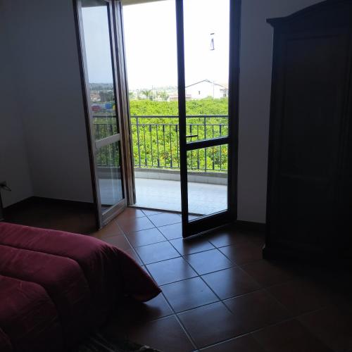 a bedroom with a door open to a balcony at aranceto dell'Etna in Mascali