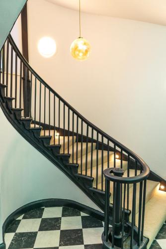 a spiral staircase with a checkerboard floor in a house at Judges suite apartment with spa facilities in Morpeth