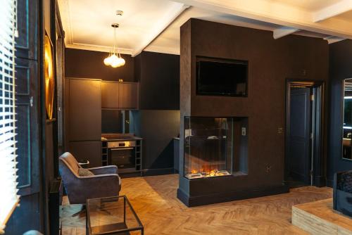 a living room with a fireplace and a chair at Judges suite apartment with spa facilities in Morpeth