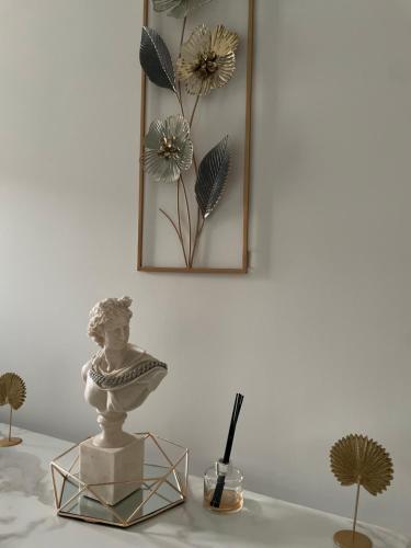 a table with a statue and flowers on a wall at The Dene in Drogheda