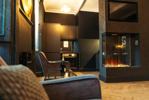 a living room with a couch and a fireplace at Judges suite apartment with spa facilities in Morpeth