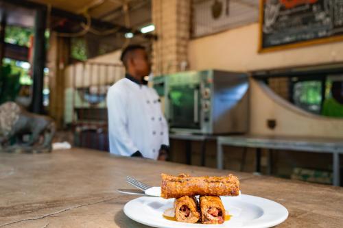 a plate of food on a counter with a fork at Shoestrings Backpackers Lodge Vic Falls in Victoria Falls