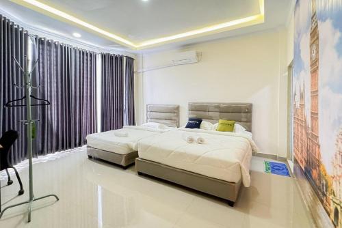 a bedroom with two beds and a large window at Urbanview Botania Meeting Point Batam by RedDoorz in Nongsa