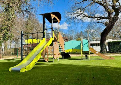 une aire de jeux avec un toboggan dans un parc dans l'établissement Camping Rivages des Landes - Eurocamp I Homair, à Aureilhan