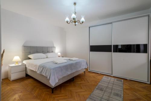 ein Schlafzimmer mit einem großen Bett und einem Kronleuchter in der Unterkunft Quiet Apartments with FREE PARKING in Sarajevo