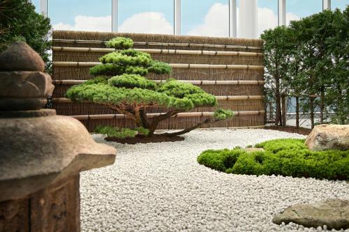 a small pine tree in a garden with gravel at Bvlgari Hotel Tokyo in Tokyo