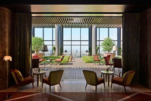 a lobby with tables and chairs and a large window at Bvlgari Hotel Tokyo in Tokyo