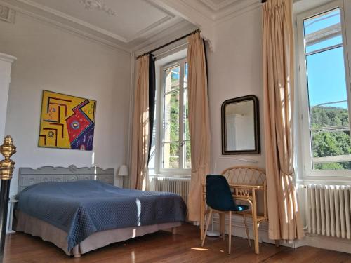 une chambre avec un lit, un bureau et des fenêtres dans l'établissement Suite familiale Joséphine à La Terrasse 2 à 4 personnes piscine local vélos, à Tournon-sur-Rhône