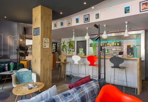 a living room with a couch and a bar at B&B HOTEL Chartres Centre Cathédrale 3 étoiles in Chartres