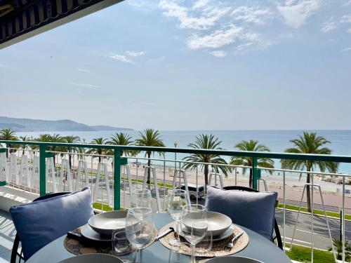- une table avec des verres à vin sur un balcon donnant sur la plage dans l'établissement Le Milord - Easy Home Booking, à Nice